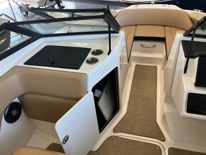 Slide: The Image of 2024 Sea Ray SPX 210 boat interior with beige seating and storage compartments. - 7
