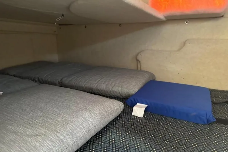 Slide: The Image of Interior sleeping area of a 2006 Bayliner 265 boat with cushions and bedding. - 11