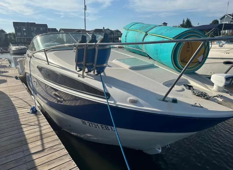 Slide: The Image of 2006 Bayliner 265 boat docked at marina with blue and white exterior. - 5