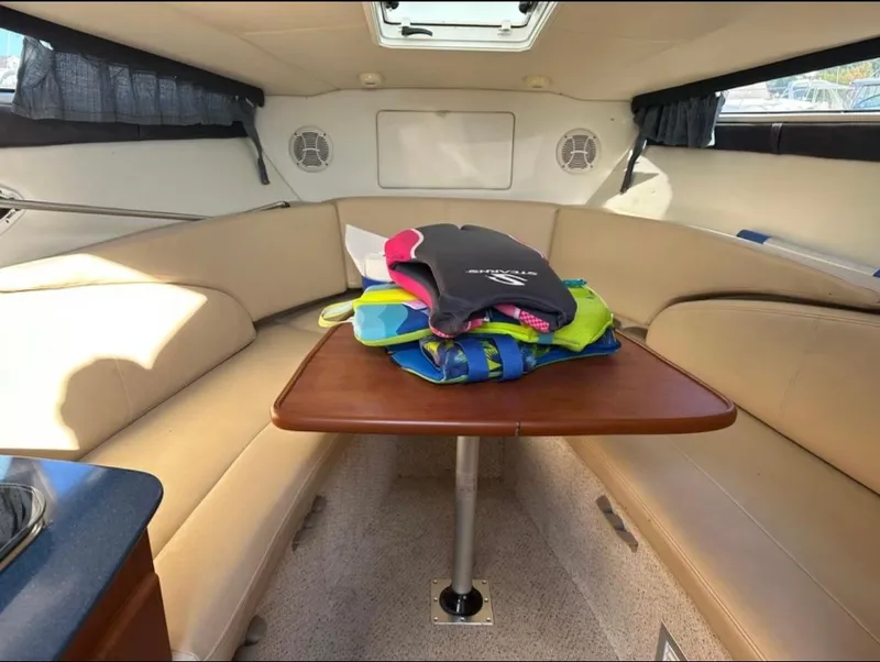 Slide: The Image of 2006 Bayliner 265 cabin interior with table and life jackets. - 9