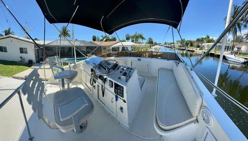 Slide: The Image of 1978 Hatteras 37 Convertible boat cockpit with helm, seating, and canal view. - 10