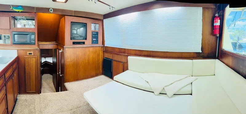Slide: The Image of 1978 Hatteras 37 Convertible yacht interior with kitchen, seating area, and entertainment center. - 3