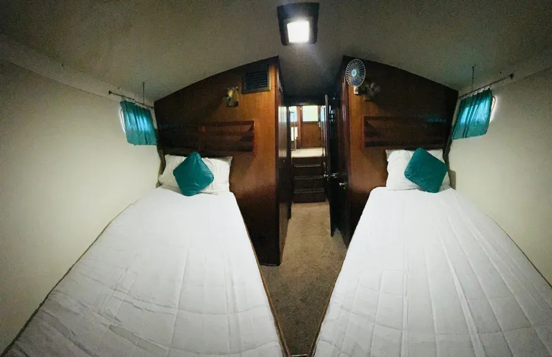 Slide: The Image of Interior cabin of a 1978 Hatteras 37 Convertible with twin beds and teal accents. - 6