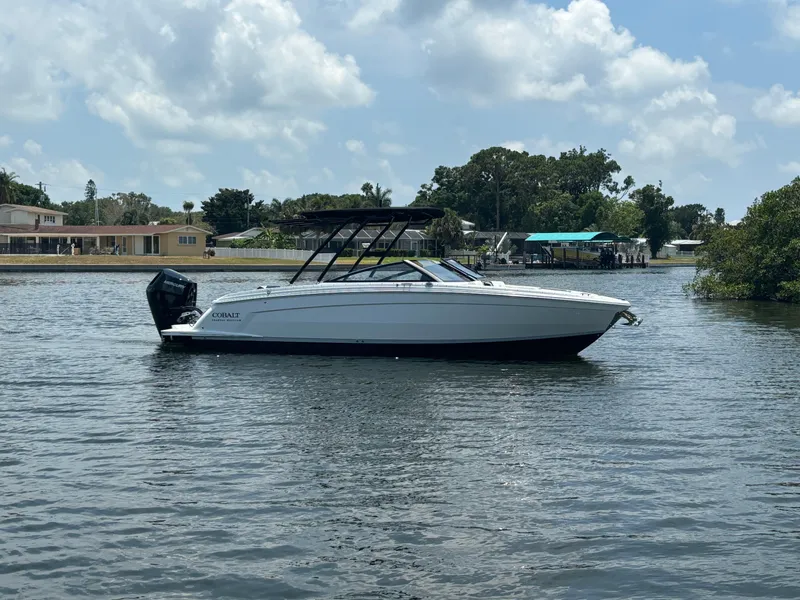 The Image of 2024 Cobalt R8 Outboard boat on calm water with houses in the background. - 0