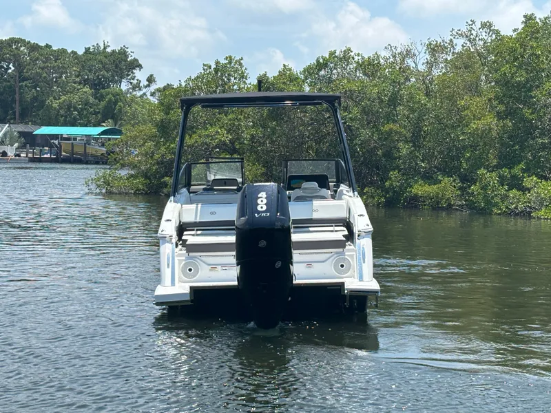 Slide: The Image of 2024 Cobalt R8 Outboard boat on a calm river with lush greenery. - 5