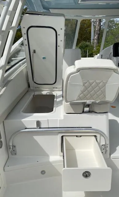 Slide: The Image of 2024 World Cat 325 DC boat interior with storage compartments and seating. - 13