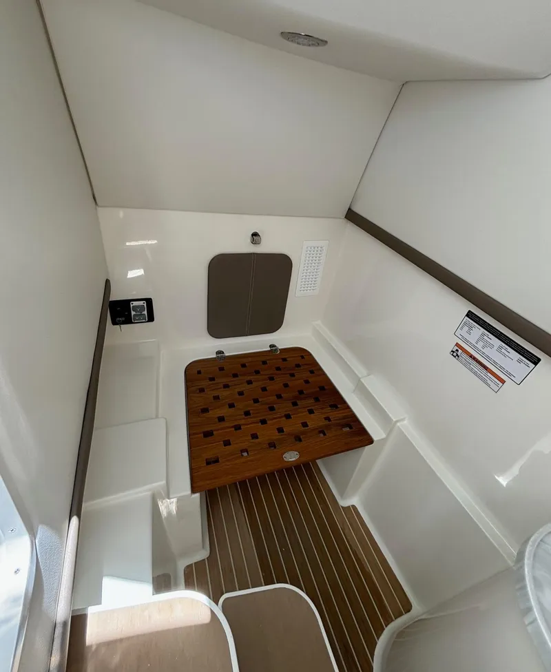 Slide: The Image of 2024 World Cat 325 DC interior cabin with wooden flooring and seating. - 16