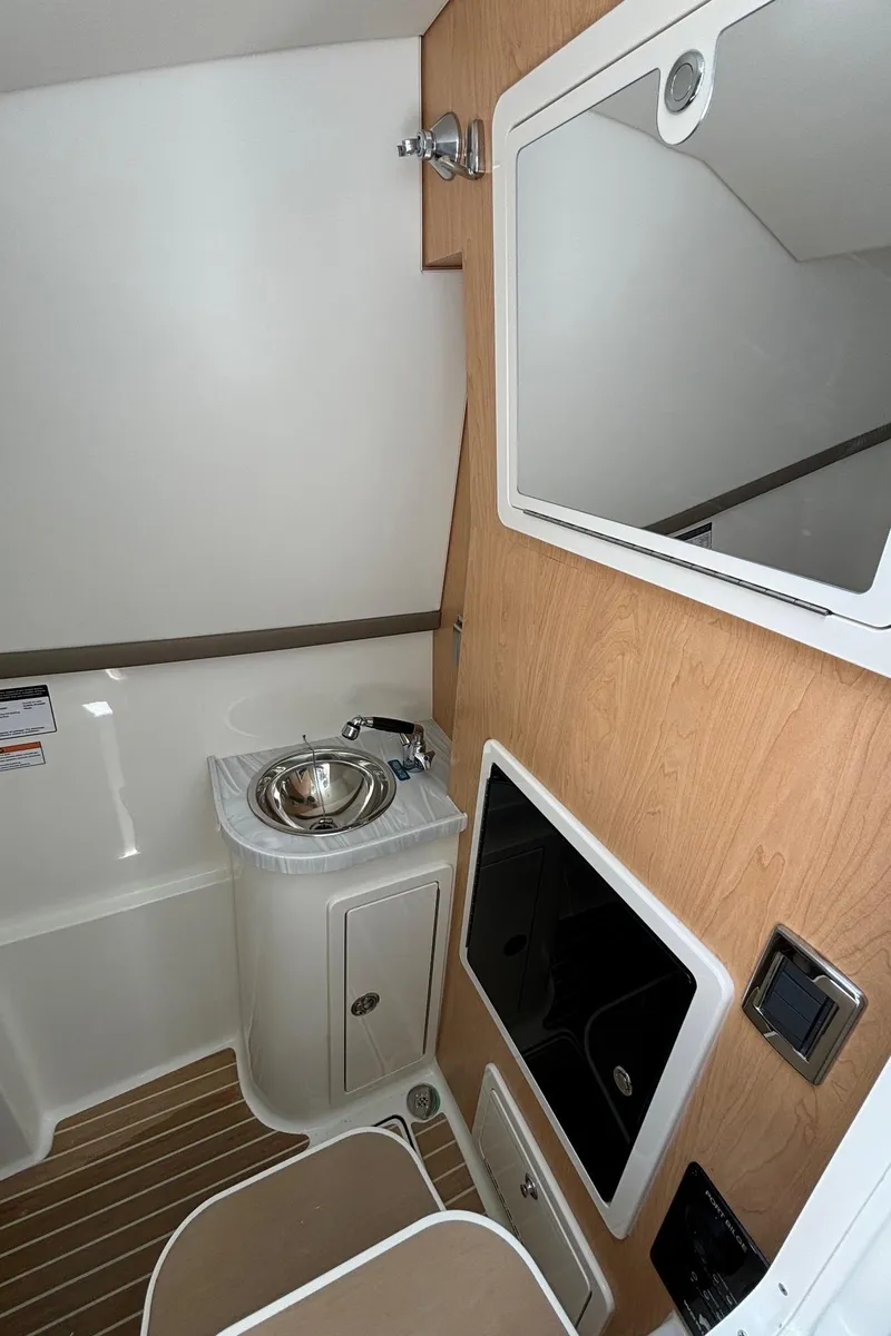 Slide: The Image of 2024 World Cat 325 DC boat interior with sink, mirror, and storage. - 17