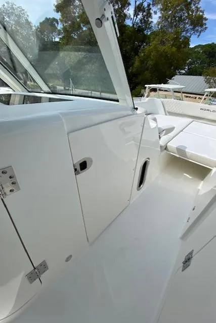 Slide: The Image of 2024 World Cat 325 DC boat interior with white seating and storage compartments. - 24