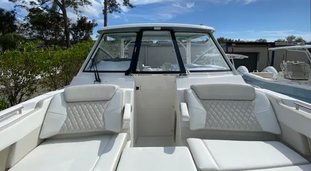 Slide: The Image of 2024 World Cat 325 DC boat with white cushioned seating and windshield. - 27