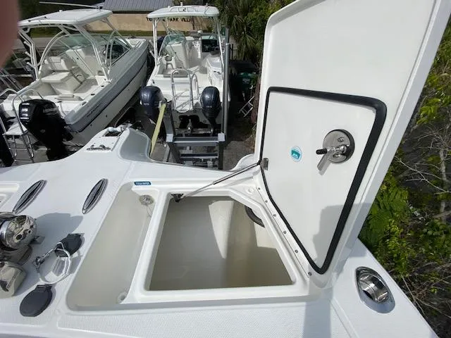 Slide: The Image of Open storage compartment on a 2024 World Cat 325 DC boat, with other boats in the background. - 31