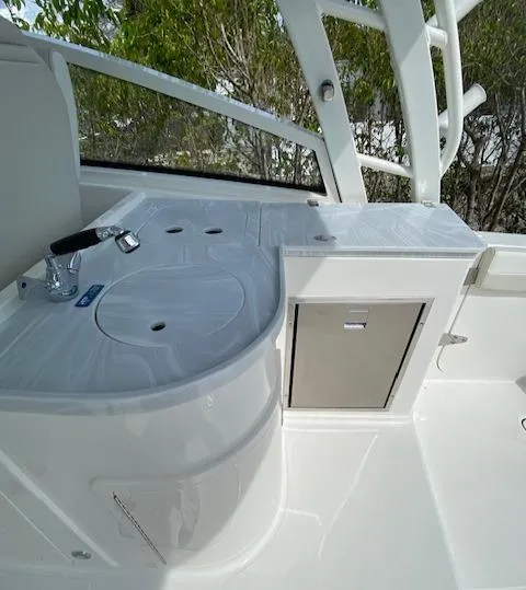 Slide: The Image of 2024 World Cat 325 DC boat interior with sink and storage compartment. - 6