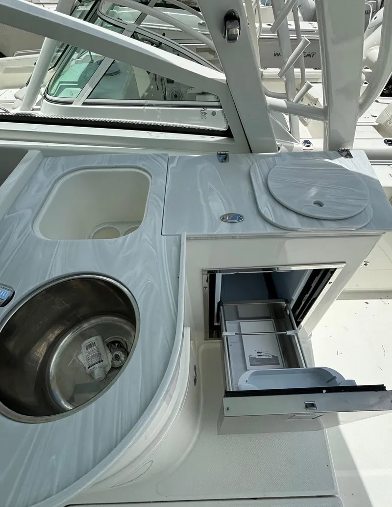 Slide: The Image of 2024 World Cat 325 DC boat kitchen area with sink and storage. - 8