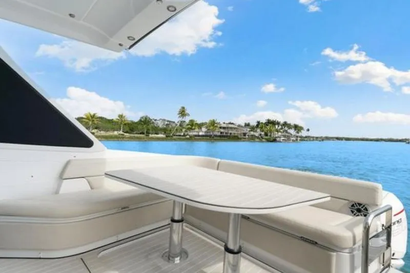 Slide: The Image of 2023 Azimut Verve 42 yacht deck with seating, table, and scenic ocean view. - 28