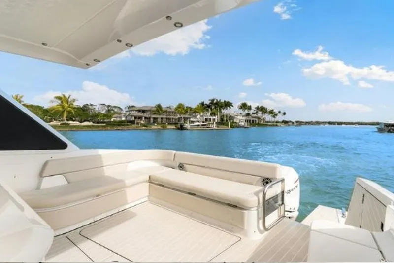 Slide: The Image of 2023 Azimut Verve 42 yacht with luxurious seating, overlooking serene waterfront homes. - 32