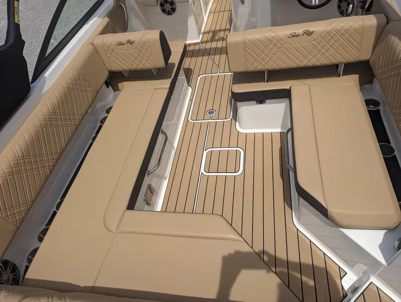 Slide: The Image of 2024 Sea Ray SDX 270 boat interior with tan seating and wood flooring. - 11