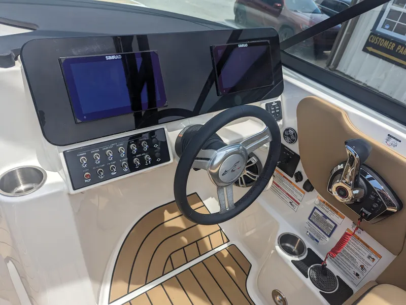 Slide: The Image of 2024 Sea Ray SDX 270 boat dashboard with dual Simrad displays and steering wheel. - 13