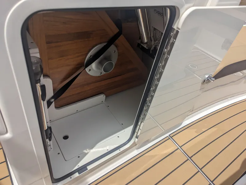 Slide: The Image of 2024 Sea Ray SDX 270 storage compartment with wooden interior and secure latch. - 21