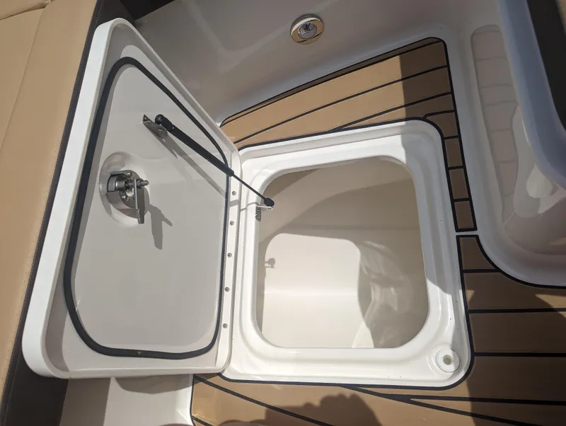 Slide: The Image of Open storage compartment on 2024 Sea Ray SDX 270 boat with teak flooring. - 22