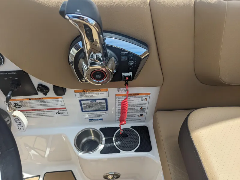 Slide: The Image of 2024 Sea Ray SDX 270 boat control panel with throttle, cup holders, and safety lanyard. - 32