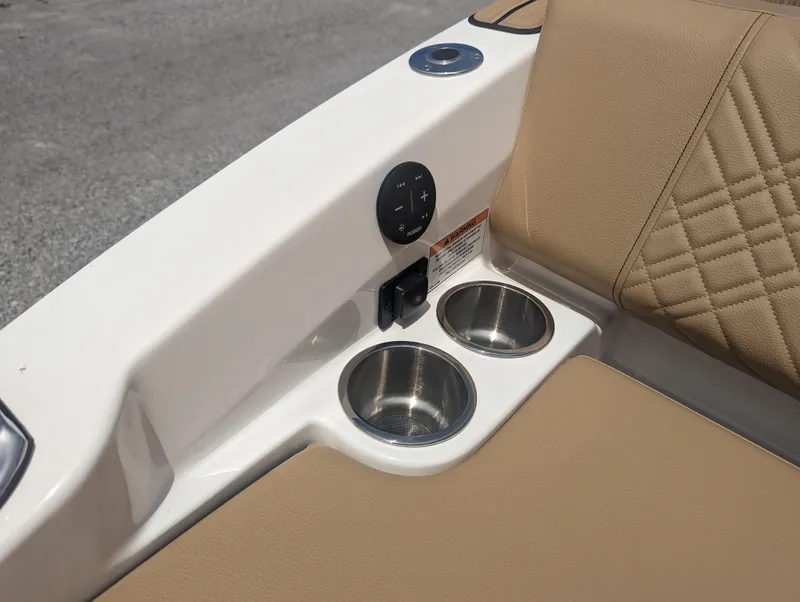 Slide: The Image of 2024 Sea Ray SDX 270 boat interior with cup holders and beige seating. - 34