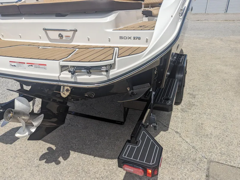 Slide: The Image of 2024 Sea Ray SDX 270 boat on trailer, rear view showing propeller and swim platform. - 38