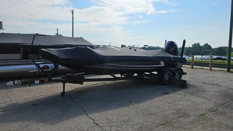 Slide: The Image of 2024 iKon LX21 boat on trailer, covered, parked outdoors under a partly cloudy sky. - 4