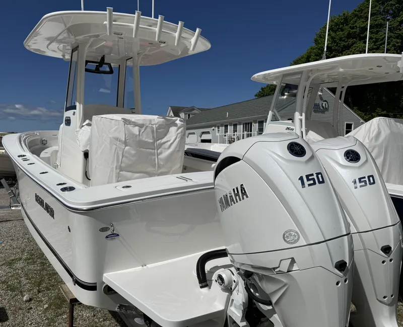 Slide: The Image of 2025 Regulator 23 boat with twin Yamaha 150 engines, docked outdoors. - 2