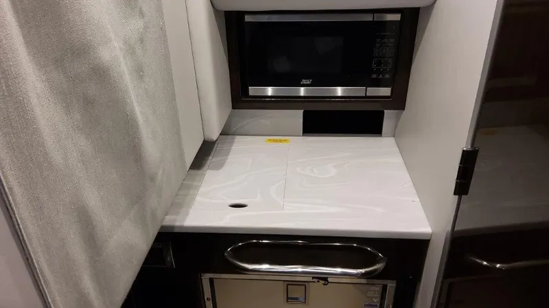 Slide: The Image of 2023 Formula 350 Crossover Bowrider I/O kitchenette with microwave and countertop. - 23
