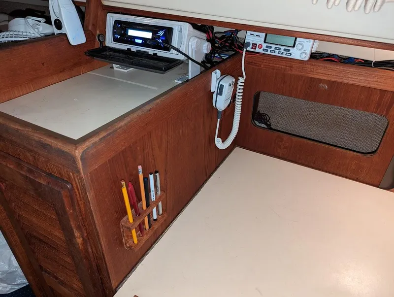 Slide: The Image of Navigation station inside a 1985 O'Day 35 sailboat with communication equipment and storage. - 10