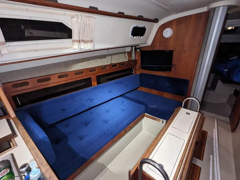 Slide: The Image of Interior of a 1985 O'Day 35 sailboat with blue seating and wooden accents. - 11