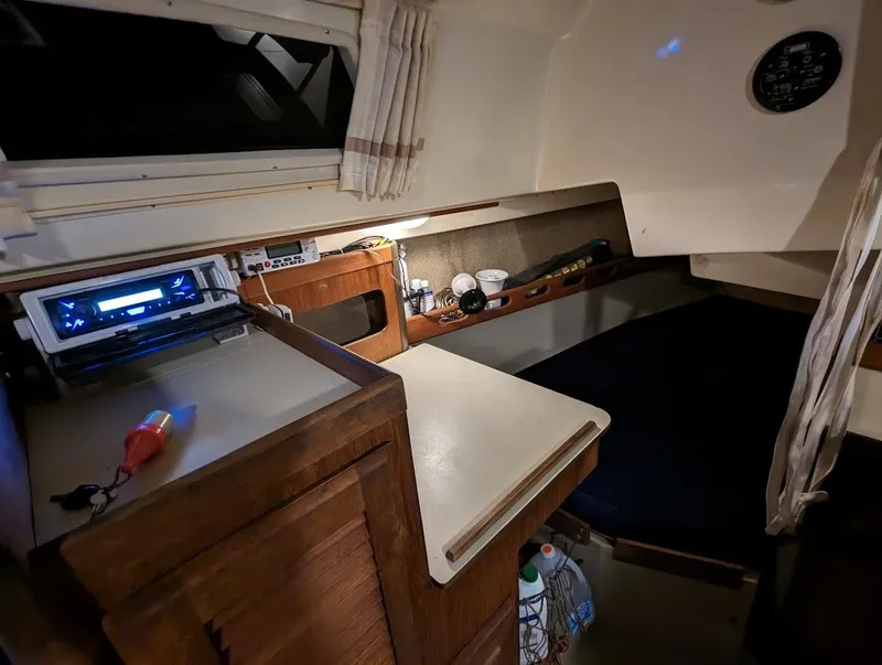 Slide: The Image of 1985 O'Day 35 sailboat interior with navigation equipment and cozy sleeping area. - 14