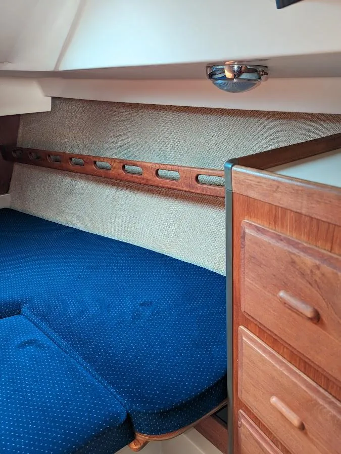 Slide: The Image of Interior cabin of 1985 O'Day 35 sailboat with blue cushions and wooden storage. - 17