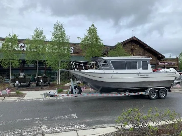 The Image of 2024 Spartan 2600 Olympia boat on trailer, parked outdoors under cloudy sky. - 0