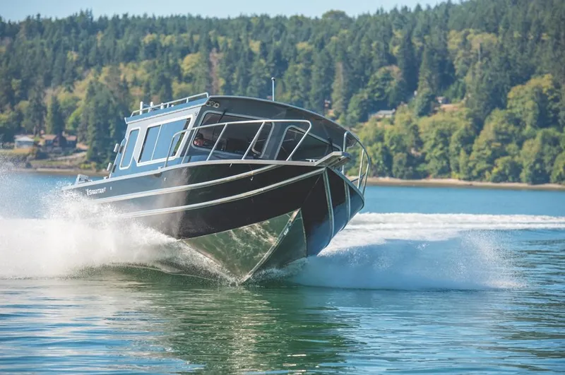 Slide: The Image of 2024 Spartan 2600 Olympia boat deck with storage compartments and dual outboard motors. - 9