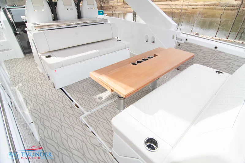 Slide: The Image of 2024 Jeanneau DB/37 OB boat interior with seating and wooden table. - 14