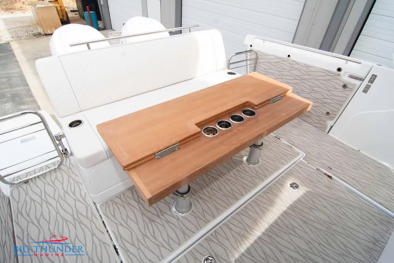 Slide: The Image of 2024 Jeanneau DB/37 OB boat interior with wooden table and cushioned seating. - 16
