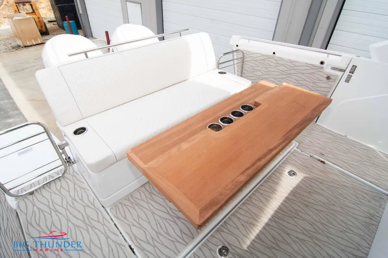 Slide: The Image of 2024 Jeanneau DB/37 OB boat interior with white seating and wooden table. - 18