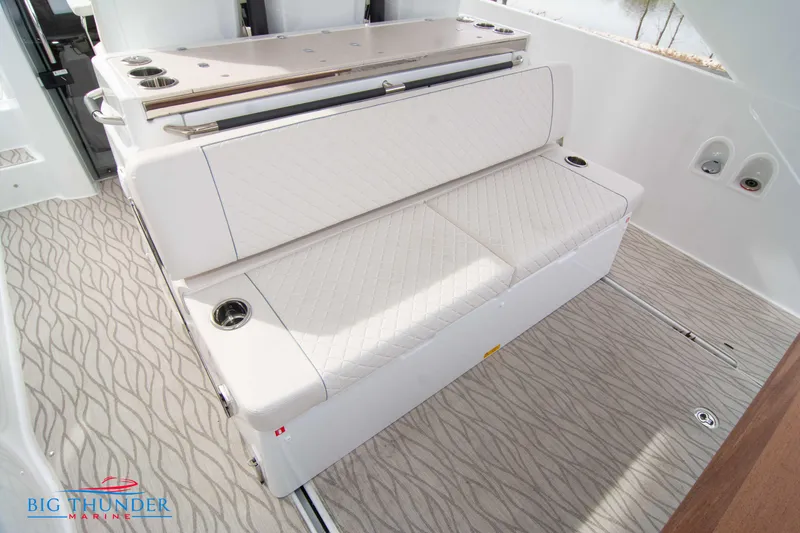 Slide: The Image of 2024 Jeanneau DB/37 OB boat interior with cushioned seating and cup holders. - 25