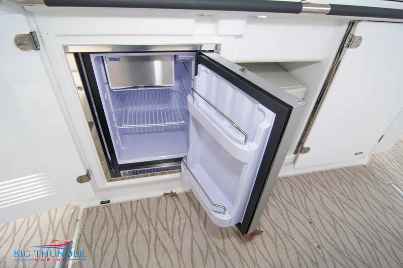 Slide: The Image of 2024 Jeanneau DB/37 OB boat interior with open refrigerator. - 31