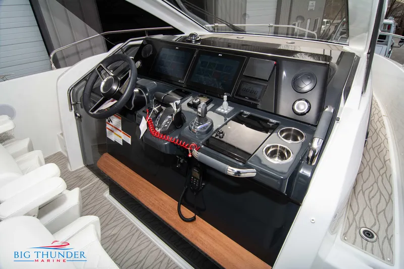 Slide: The Image of 2024 Jeanneau DB/37 OB boat cockpit with advanced navigation controls and steering wheel. - 39