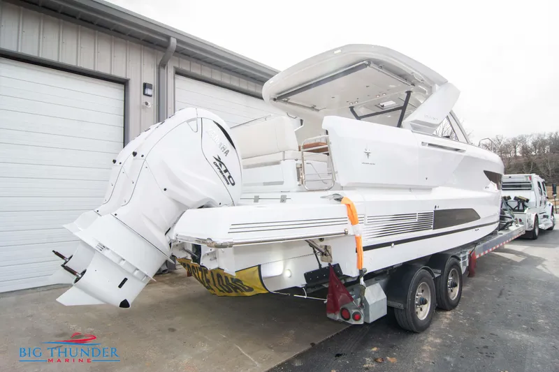 Slide: The Image of 2024 Jeanneau DB/37 OB boat on trailer outside a garage. - 9