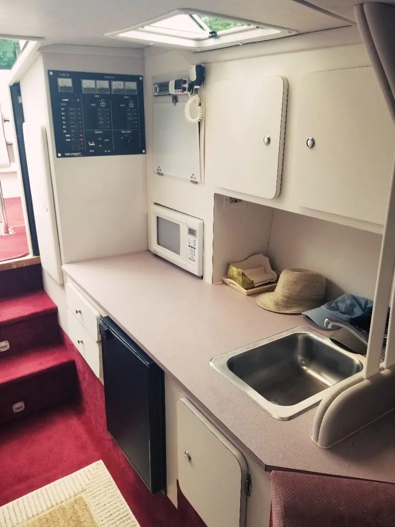 Slide: The Image of 1985 Wellcraft Excalibur Eagle 42 boat interior kitchen with sink, microwave, and control panel. - 8