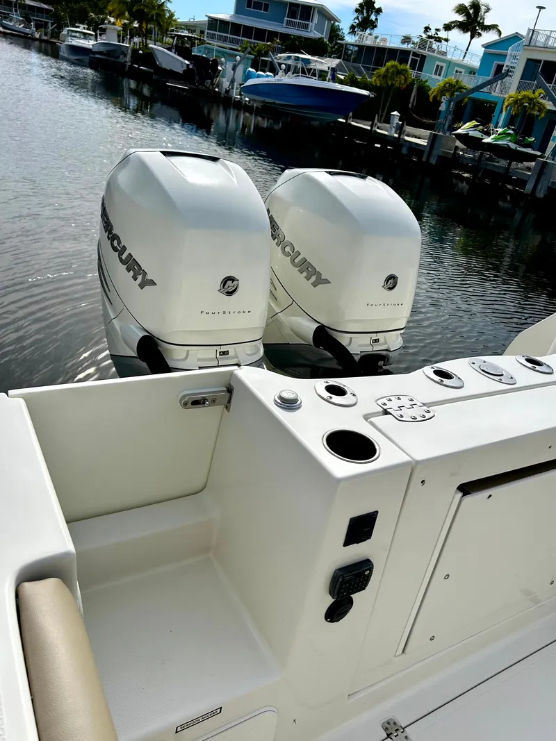 Slide: The Image of 2017 Sailfish 325 DC boat with twin Mercury outboard engines docked in a marina. - 39