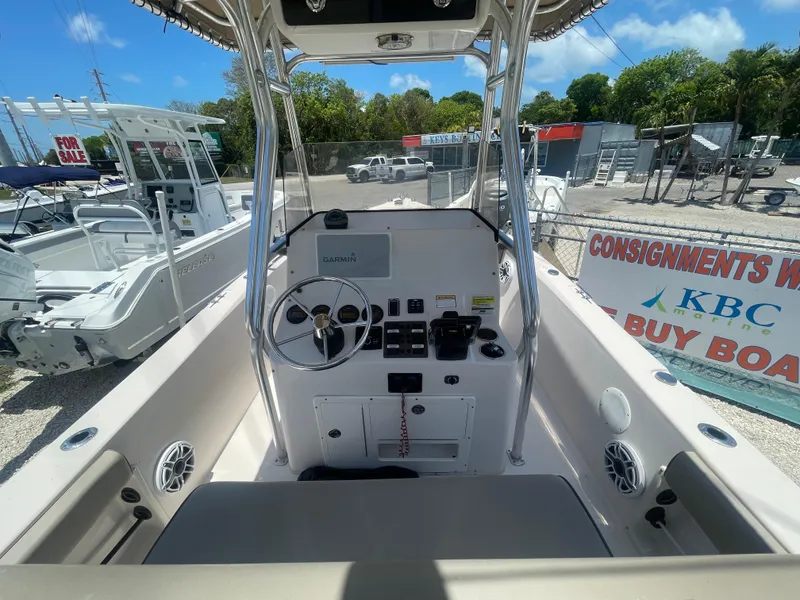 Slide: The Image of 2006 Cobia 254 Center Console boat dashboard and controls in a marina. - 6