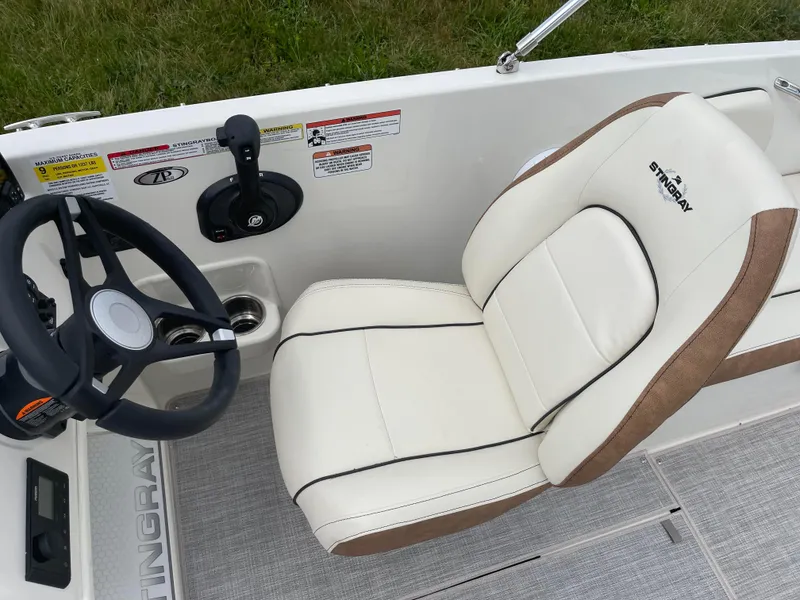 Slide: The Image of 2024 Stingray 182 SC boat interior with steering wheel and captain's chair. - 11