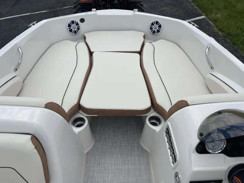 Slide: The Image of 2024 Stingray 182 SC boat interior with white cushioned seating and cup holders. - 12