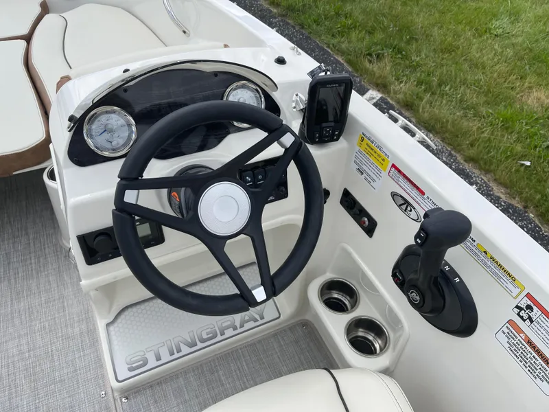 Slide: The Image of 2024 Stingray 182 SC boat dashboard with steering wheel and control panel. - 3