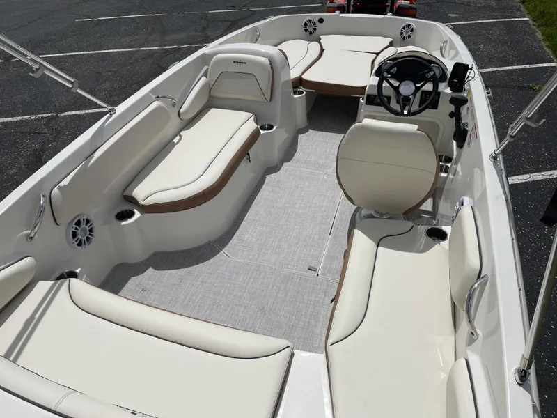 Slide: The Image of 2024 Stingray 182 SC boat interior with white seating and steering console. - 6