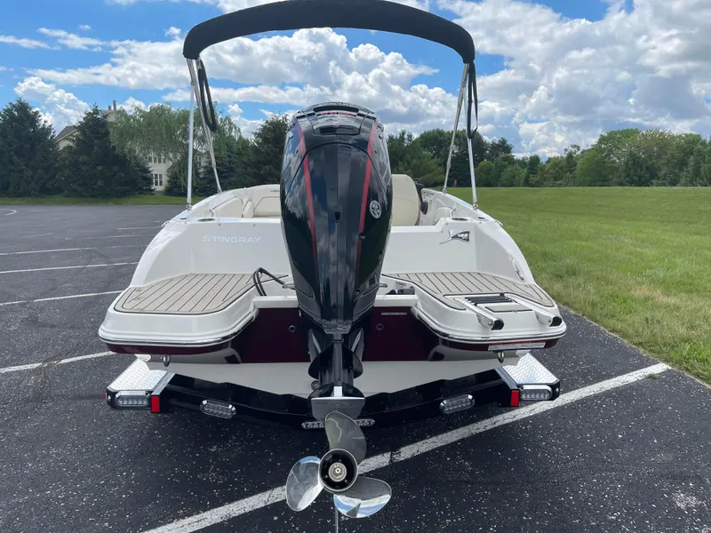 Slide: The Image of 2024 Stingray 182 SC boat with outboard motor, rear view on asphalt lot. - 8